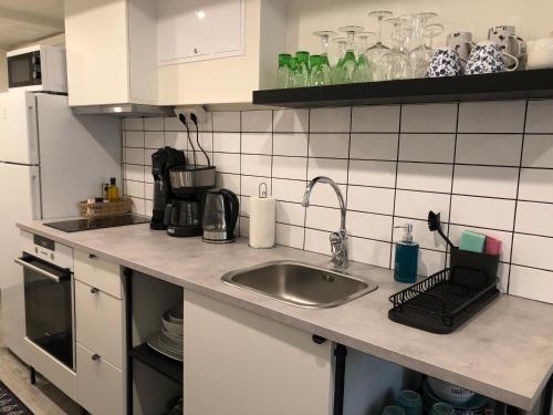 eine Küche mit einer Spüle und einer Arbeitsplatte in der Unterkunft Near commuter train to Stockholm in Södertälje
