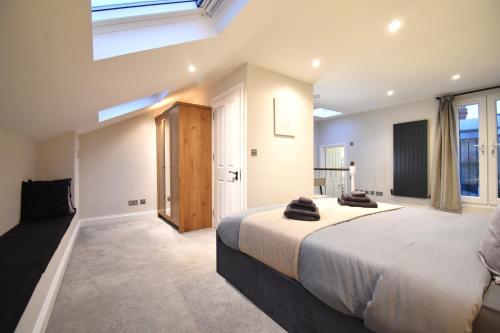 - une grande chambre avec un grand lit et des fenêtres dans l'établissement Stunning 3 Bed Apartment, à Londres