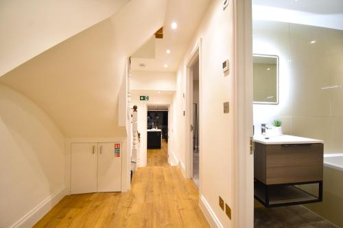 pasillo de una casa con escalera y lavabo en Stunning 3 Bed Apartment, en Londres