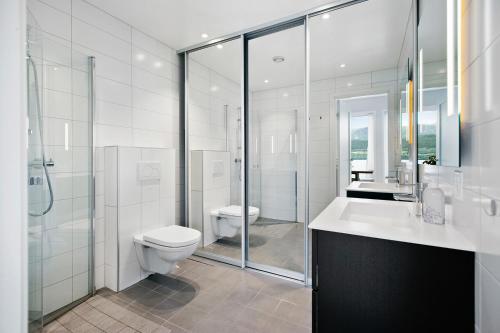 La salle de bains est pourvue de toilettes, d'un lavabo et d'une douche. dans l'établissement Fantastisk sommerhus i Tennfjord, ved Ålesund., à Tennfjord
