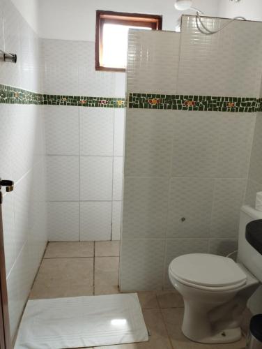 a bathroom with a toilet and a shower at Pousada Luz do Sol in Sao Jorge