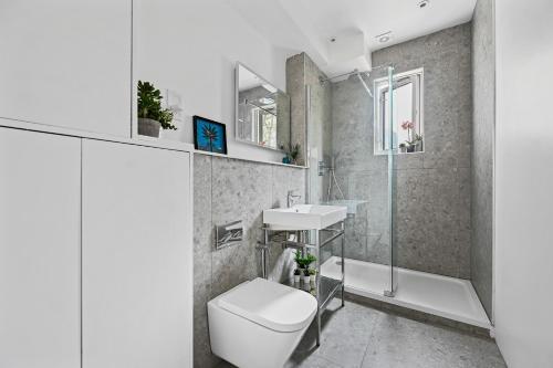 La salle de bains est pourvue de toilettes et d'un lavabo. dans l'établissement Nightingale Suites, à Londres