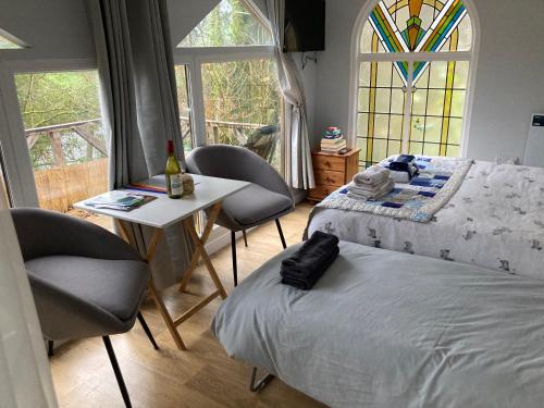 a bedroom with a bed and a table and chairs at Honey Bee Cabin in Llandysul