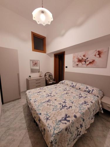 a bedroom with a bed and a chair at I ciclamini in Monopoli