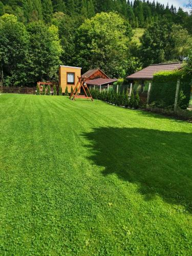 a yard with a large lawn with a house at Malý kúsok raja in Reľov