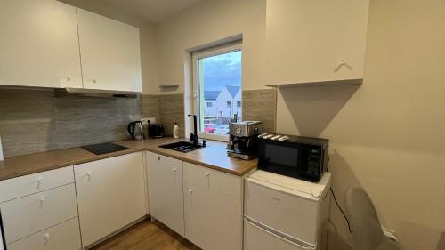a kitchen with a microwave on a counter with a window at Apartment Golden Prague 78 in Vestec