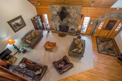 Ofrece vistas panorámicas a una sala de estar con sofás y una chimenea de piedra. en Buffalo River Lodge St Joe AR en Maumee