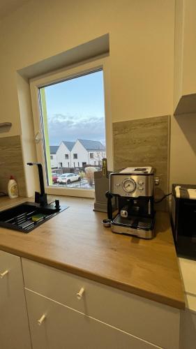a kitchen counter with a coffee maker and a window at Apartment Golden Prague 78 in Vestec