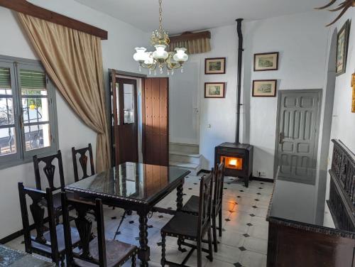 ein Esszimmer mit einem Tisch und einem Holzofen in der Unterkunft Casa Rural Patio in La Puebla de los Infantes