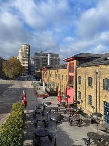 a row of tables and chairs in front of a building at Apartment 3, Warehouse K in London
