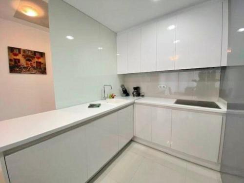 La Horadada的住宿－Appartement Mil palmeras，白色的厨房配有白色橱柜和水槽
