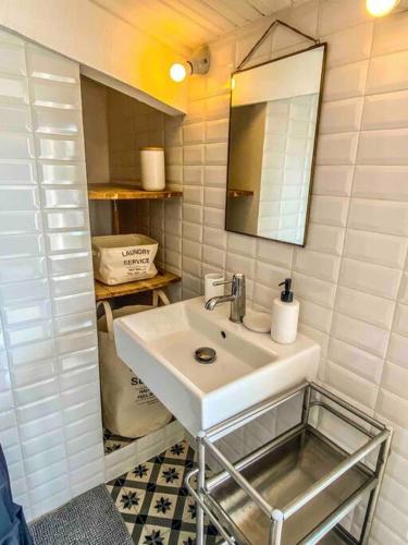 une salle de bain avec un lavabo blanc et un miroir dans l'établissement Hypercentre terrasse clim Duplex, à Aix-en-Provence