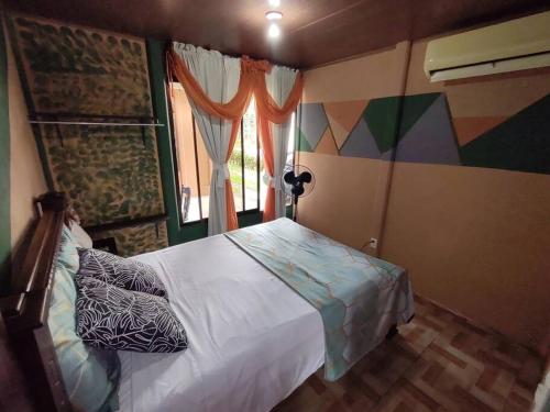 a bedroom with a bed and a window at Palm house Arenal in Fortuna