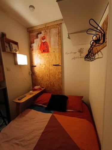 - une chambre avec un lit et une porte en bois dans l'établissement Studio 10m2, terrasse 18m2 , parking, piscine et accueille les animaux, à Quissac