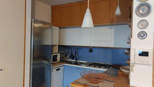a kitchen with a stainless steel refrigerator and wooden cabinets at Il Girasole in Milan