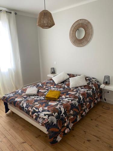1 dormitorio con cama con edredón y espejo en Le 122 - Parking, en Rodez