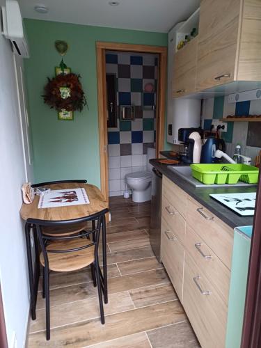 eine kleine Küche mit einem Tisch und einem Waschbecken in der Unterkunft Le coup de foudre in Barr
