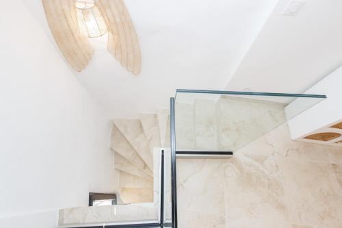 un ascenseur en verre dans une chambre avec un escalier en marbre dans l'établissement CASA Farniente Appartement Cocooning Provence Verte, à Montfort-sur-Argens