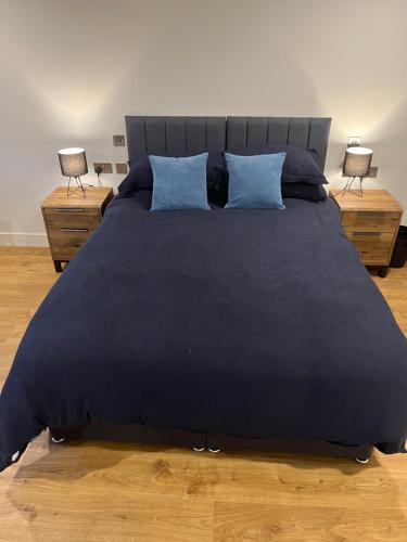 a bedroom with a large bed with blue pillows at Green haven in Winford