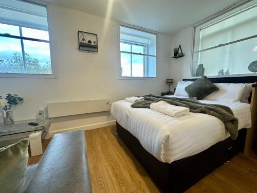 a bedroom with a large bed and two windows at Chamber Apart City Centre BD1 in Bradford