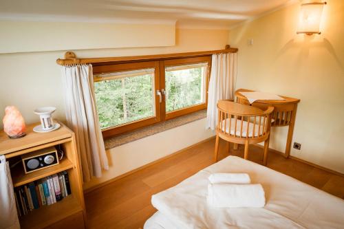 a bedroom with a bed and a desk and a window at Panoramahotel Wagner - Das Biohotel am Semmering in Semmering