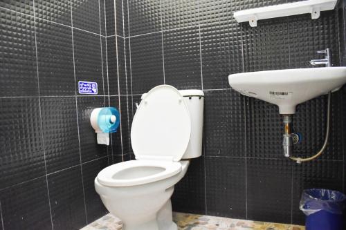La salle de bains est pourvue de toilettes et d'un lavabo. dans l'établissement รีสอร์ทบ้านพระร่วง พระปรางค์ ศรีสัชนาลัย, 