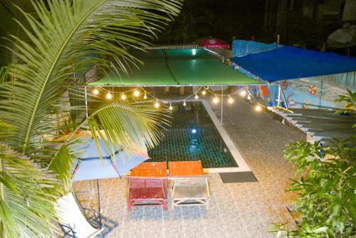- une vue sur la piscine la nuit dans l'établissement รีสอร์ทบ้านพระร่วง พระปรางค์ ศรีสัชนาลัย, 
