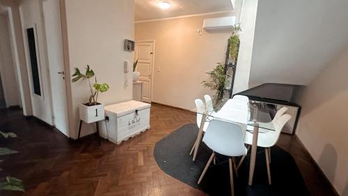 a dining room with a glass table and white chairs at Hermoso apartamento centrico! in Salta