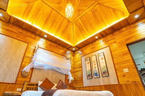 a bedroom with a wooden ceiling and two beds at Green Mountain Homestay in Ninh Binh