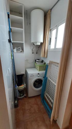 uma lavandaria com uma máquina de lavar roupa e uma máquina de lavar roupa em Relax, mar y sol em Torrevieja