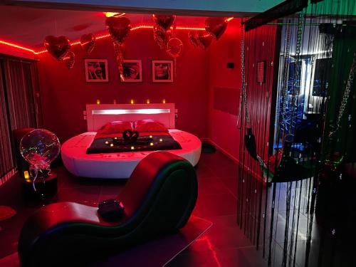 um quarto vermelho com uma cama e uma cadeira em Loft d'amour em Ligné