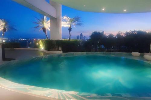 a large swimming pool in a building with palm trees at Aveline Suites Elite Rockwell view ACQUA Private Residences near Rockwell Makati in Manila