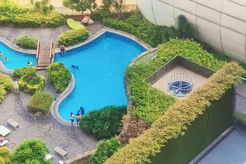 a model of a pool with people standing around it at Aveline Suites Elite Rockwell view ACQUA Private Residences near Rockwell Makati in Manila