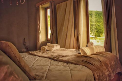 a bed in a room with a window at B&B EcoAntico casa in paglia in Maiolo