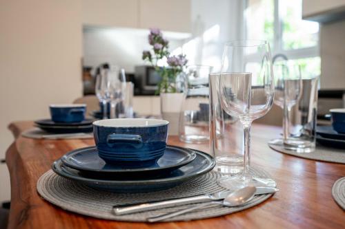 a table with plates and glasses on a wooden table at Moderne Wohnung mit Parkplatz in Ostermundigen