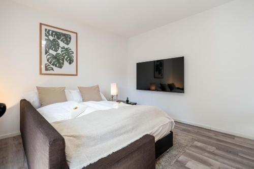 a bedroom with a large bed and a tv on the wall at Moderne Wohnung mit Parkplatz in Ostermundigen