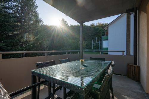 a table and chairs on a balcony with the sun shining at Moderne Wohnung mit Parkplatz in Ostermundigen