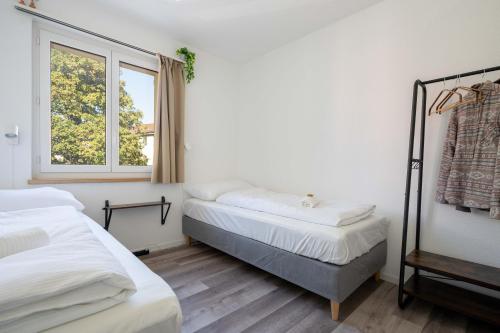 1 dormitorio con 2 camas y ventana en Moderne Wohnung mit Parkplatz en Ostermundigen