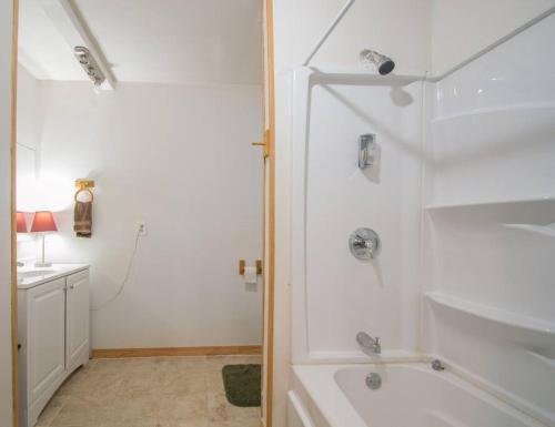 a white bathroom with a shower and a sink at Barn house in Saint Joe