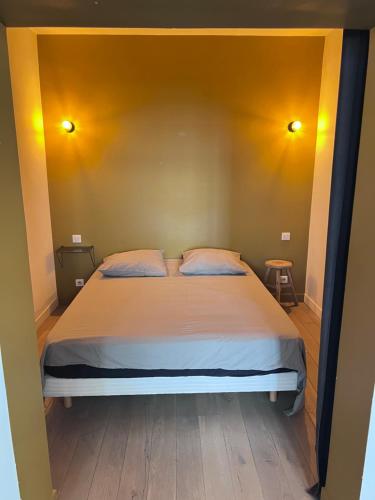 - une chambre avec un grand lit et un mur jaune dans l'établissement App 50m2 / Clim ctr historique, à Aix-en-Provence