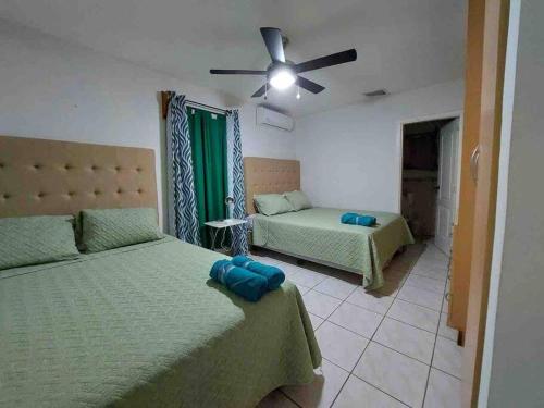a bedroom with two beds and a ceiling fan at Villa de Ali in Palma real in La Ceiba