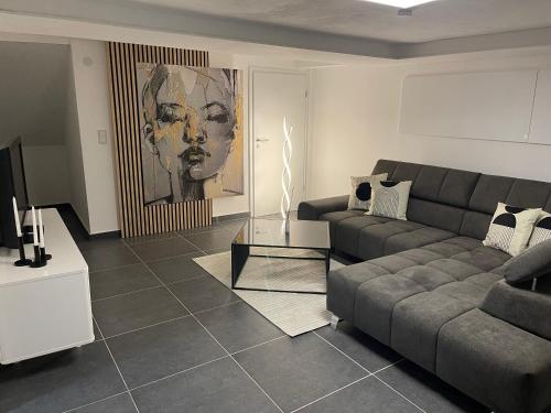 ein Wohnzimmer mit einem Sofa und einem Tisch in der Unterkunft Stilvolles Designappartment mit Terasse & Garten im idylischem Bindlach in Bindlach