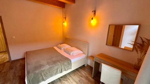 a small bedroom with a bed and a mirror at Apartmány LehotSKI Guest House in Pavčina Lehota
