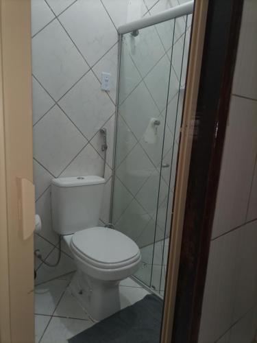 uma casa de banho com um WC e uma cabina de duche em vidro. em Casa Eco Via Norte - MCZ em Maceió