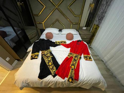 two dolls dressed in costumes laying on a bed at Luxury apartment by versace in Istanbul