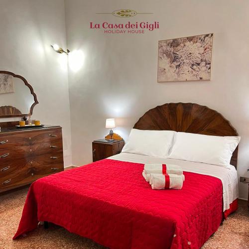 een slaapkamer met een groot bed en een rode deken bij La Casa dei Gigli in Lecce