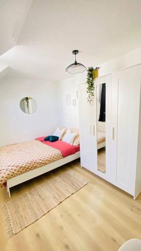 une chambre avec un lit et un miroir dans l'établissement Appartements Cosy Le Havre, au Havre