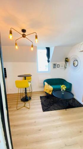un salon avec un canapé vert et une table dans l'établissement Appartements Cosy Le Havre, au Havre