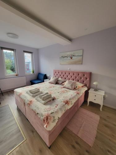 a bedroom with a large bed with a pink headboard at Villa Vino & Grad in Zagreb