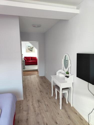 a white bedroom with a vanity and a mirror at Villa Vino & Grad in Zagreb
